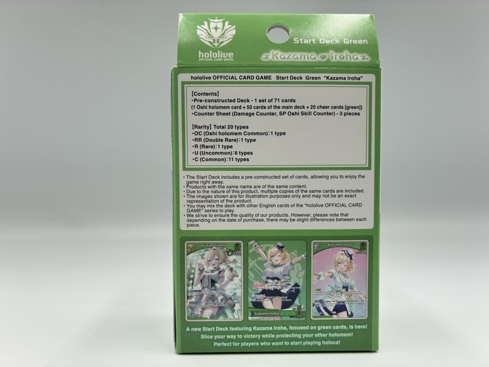 The back of a green Hololive official card game box showing product contents, rules text, and three character illustrations on a light gray background.